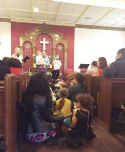 Crowd of people in a church gather for worship. 